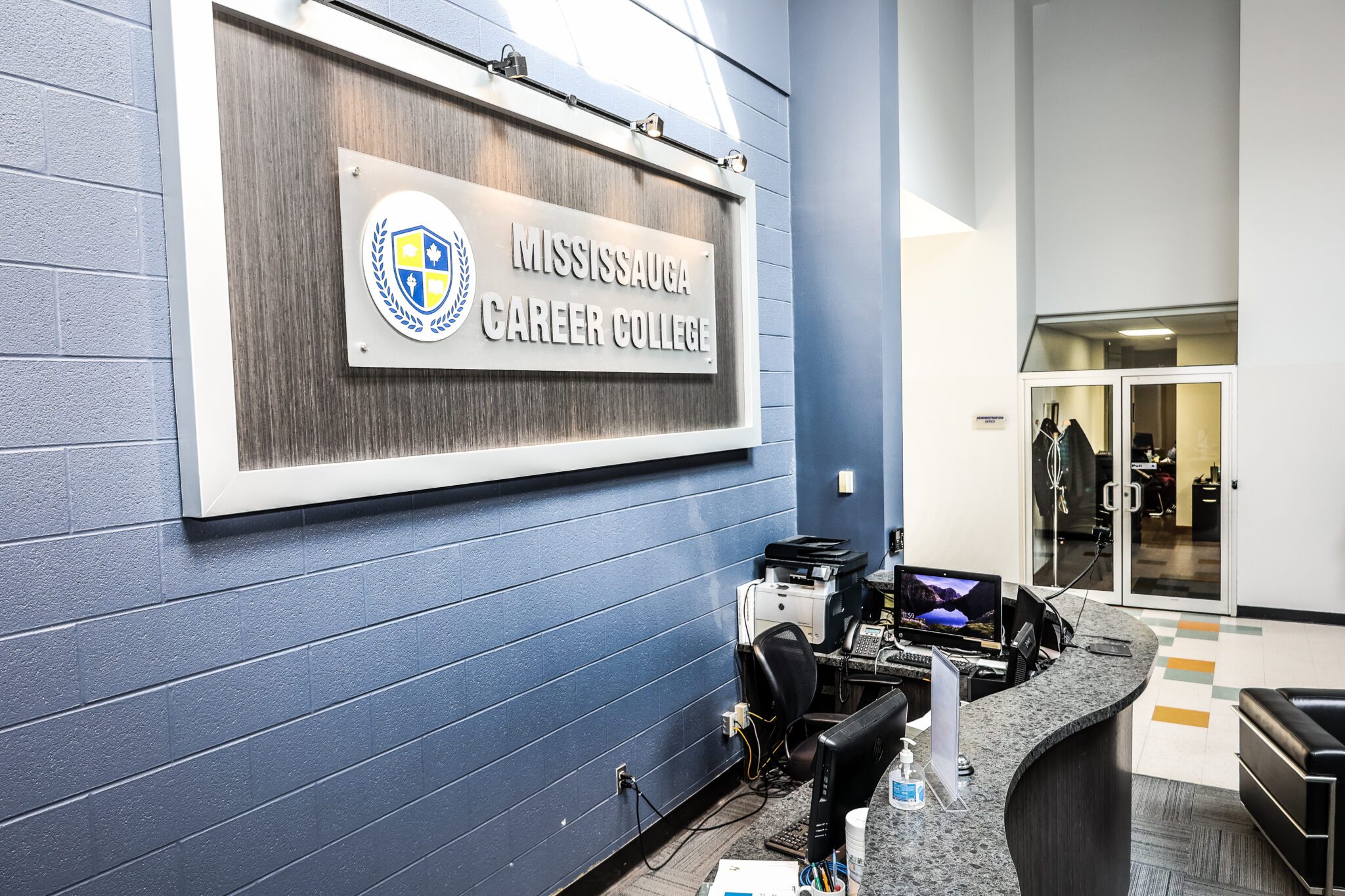 The reception desk at MCC, with the Mississauga Career College sign on the wall