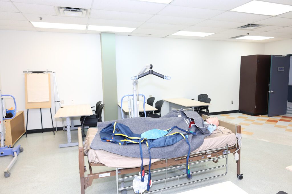 The patient care lab at MCC, with a hospital bed, training mannequin and patient lift
