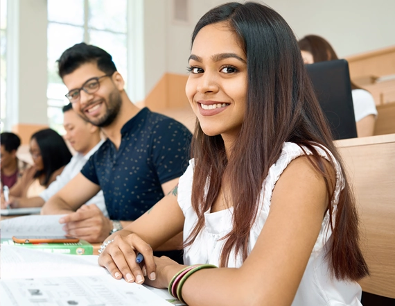 Smiling students studying together in a classroom